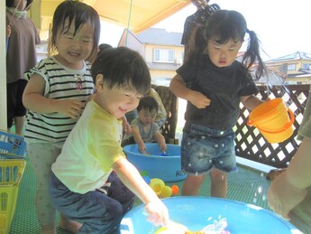 写真：友達と水遊びを楽しんでいる園児