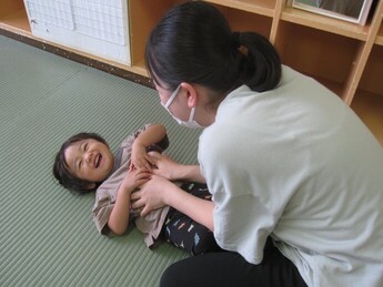 写真:保育者とふれあい遊びをする子ども