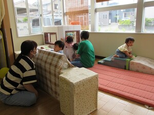 写真：保育士に見守られながら遊びを楽しんでいるところ