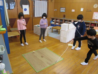 写真：保育室でコマを回しているところ