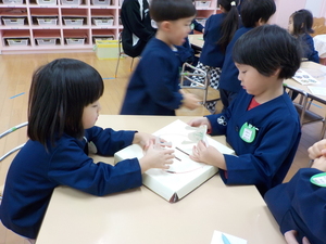 写真:友達と向かい合ってトントンずもうを楽しむ園児