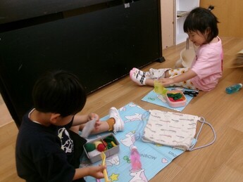 遠足の時の様子を再現してシートを広げお弁当を楽しむ写真