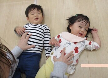 （寝転んで笑っている子どもたちの写真）