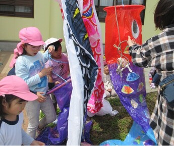 子どもたちがこいのぼりをあげている様子