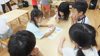 どの野菜が浮くか沈むかをグループで話し合う子ども達。
