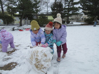友達と一緒に雪だるまを作っているところ