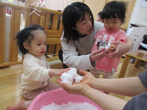 保育室で雪を触っている写真