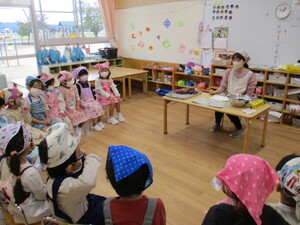 写真：給食先生にスイカをみせてもらっている様子