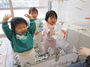 細かくなった新聞紙を舞い上げて遊んでいる様子