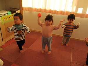 写真:どんぐりマラカスを持っている3人の園児